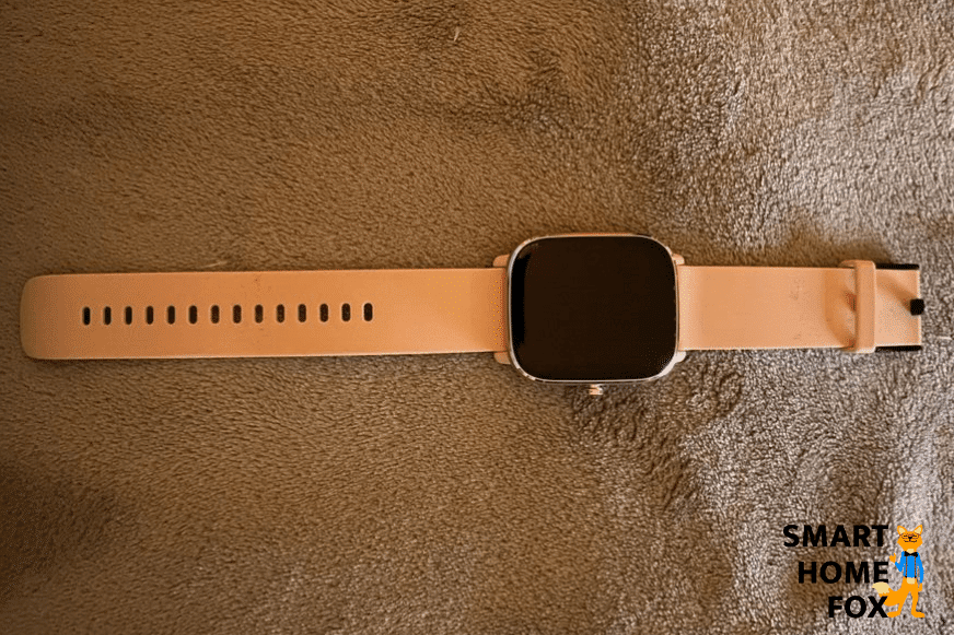 Die Amazfit GTS 2 Mini in oranger Farbe liegt auf einer Decke